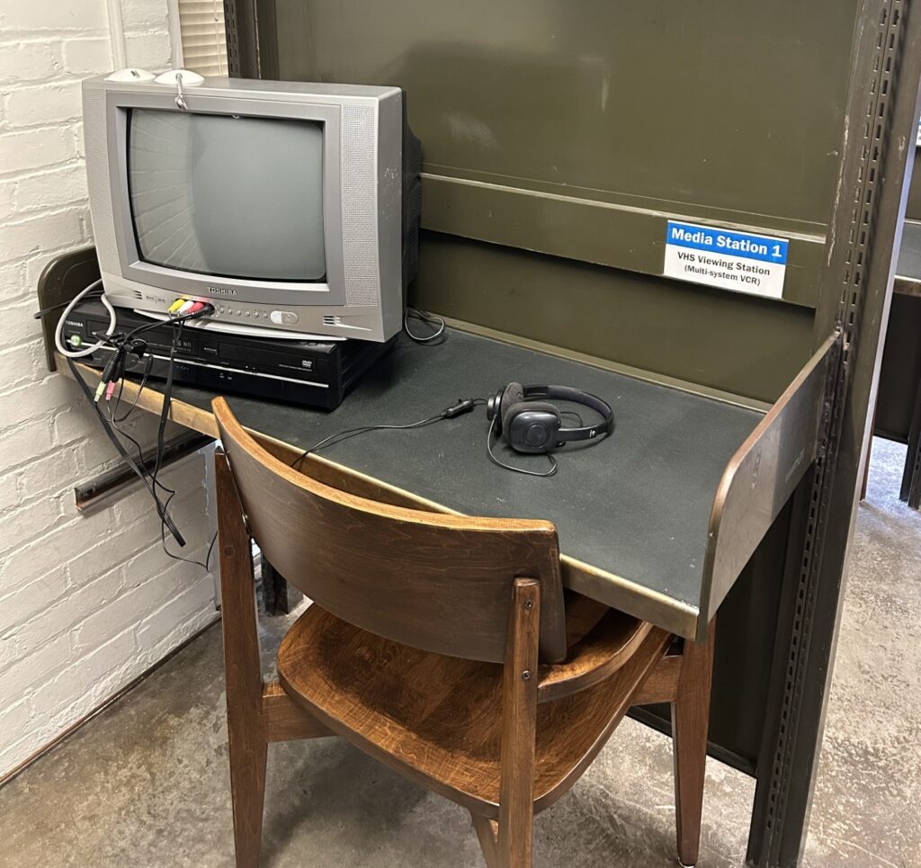 Media viewing station with a computer monitor, DVD player, and headphones.